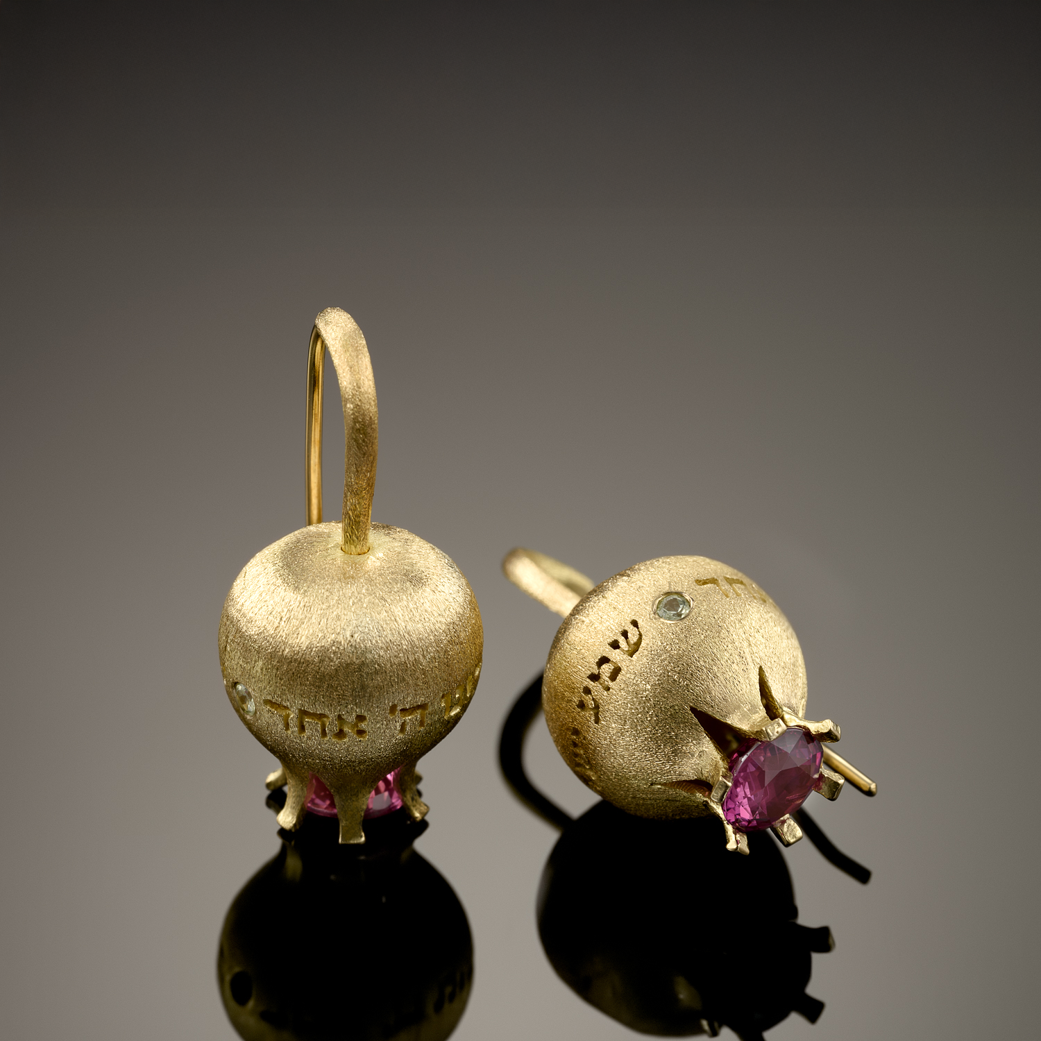 The finished pomegranate earrings in 18K gold, set with a ruby